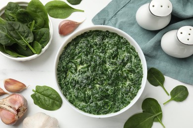 Delicious spinach sauce in bowl and spices on white marble table, flat lay