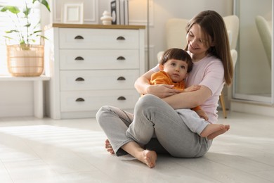 Photo of Happy mother hugging her little son at home. Space for text