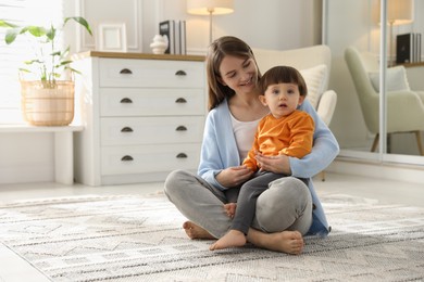 Photo of Happy mother with her little son at home. Space for text