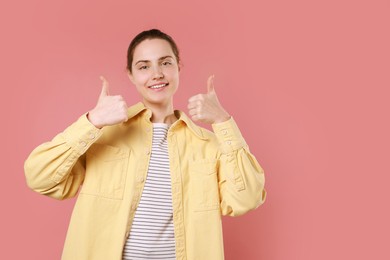 Photo of Happy woman showing thumbs up on pink background, space for text. Like gesture