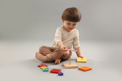 Photo of Cute little boy playing on grey background