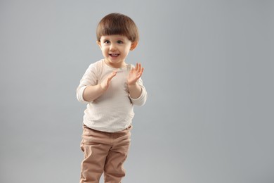 Photo of Portrait of happy little boy on grey background. Space for text