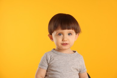 Photo of Portrait of cute little boy on yellow background. Space for text