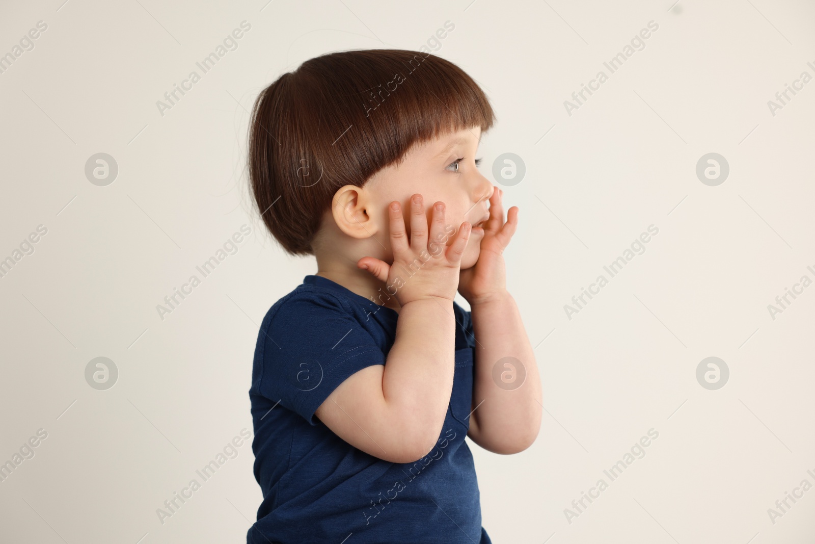 Photo of Portrait of cute little boy on light grey background