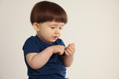 Photo of Portrait of cute little boy on light grey background. Space for text