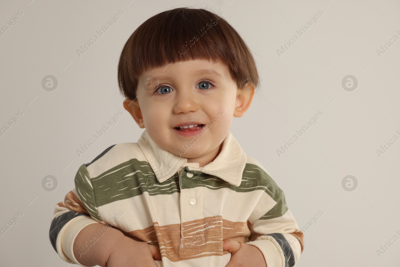 Photo of Portrait of happy little boy on light grey background