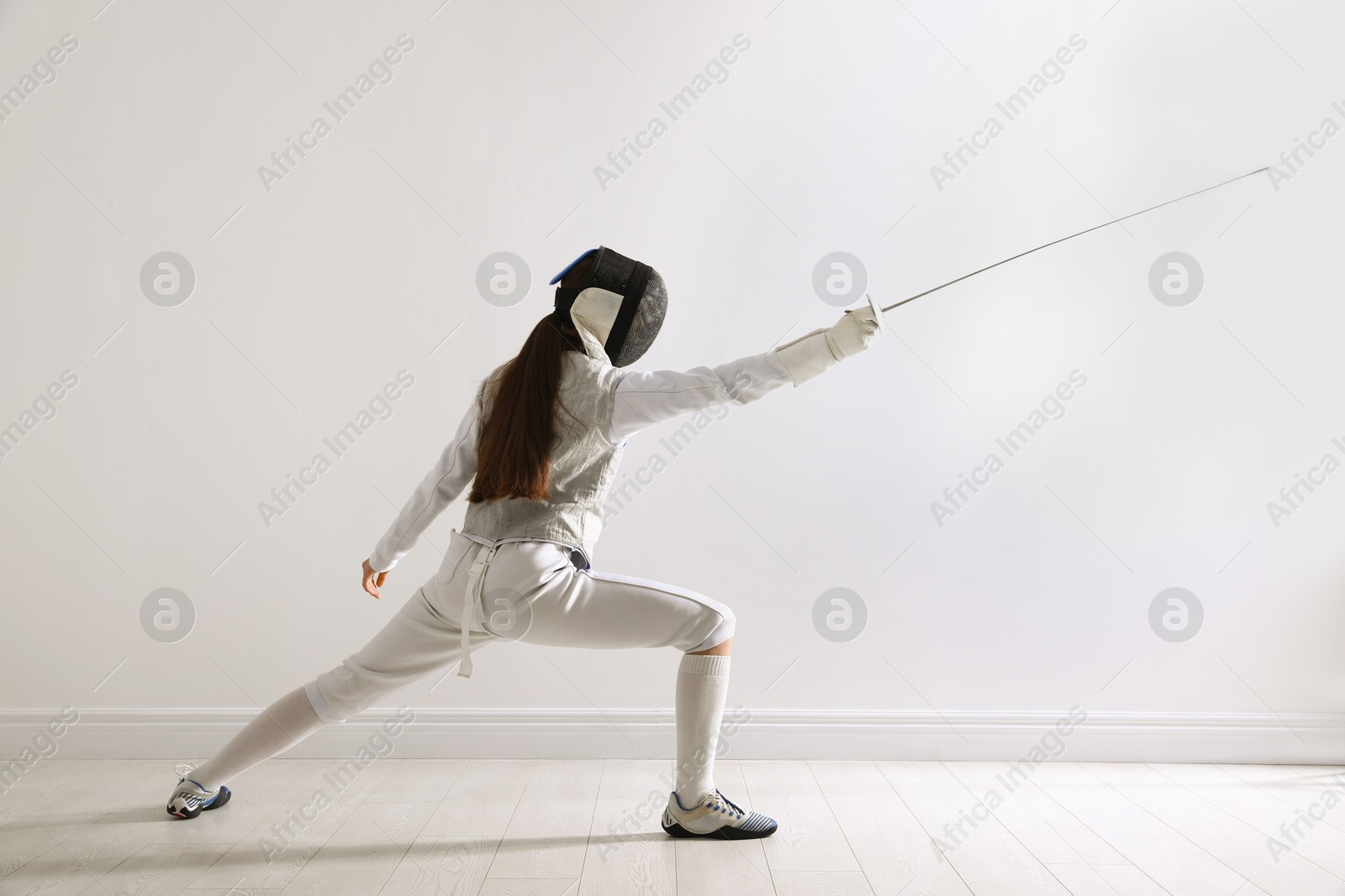 Photo of Fencer with epee practicing indoors. Combat sport