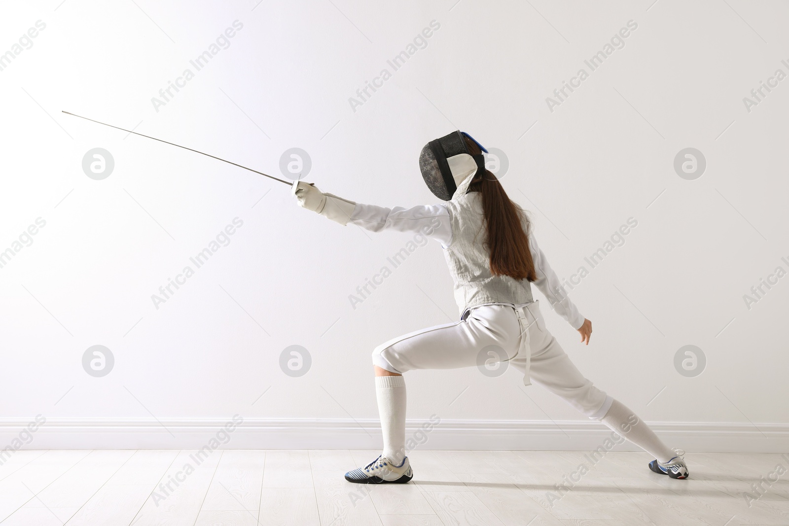 Photo of Fencer with epee practicing indoors. Combat sport