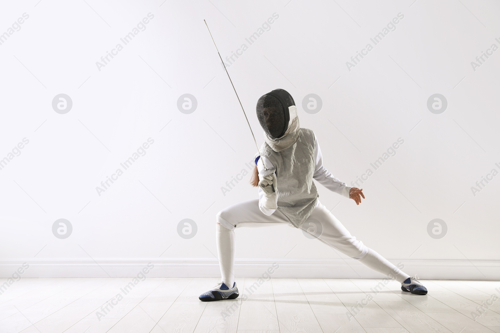 Photo of Fencer with epee practicing indoors, space for text. Combat sport