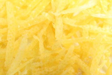 Photo of Fresh lemon zest as background, closeup view