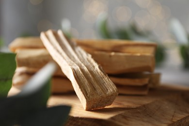 Photo of Palo santo sticks on wooden board, closeup