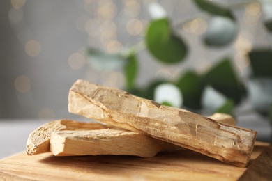 Photo of Palo santo sticks on wooden board, closeup