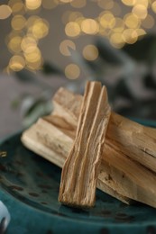 Photo of Palo santo sticks on plate, closeup view