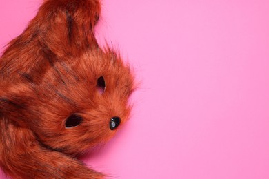 Photo of Quadrobics. Fox mask and tail on pink background, top view. Space for text