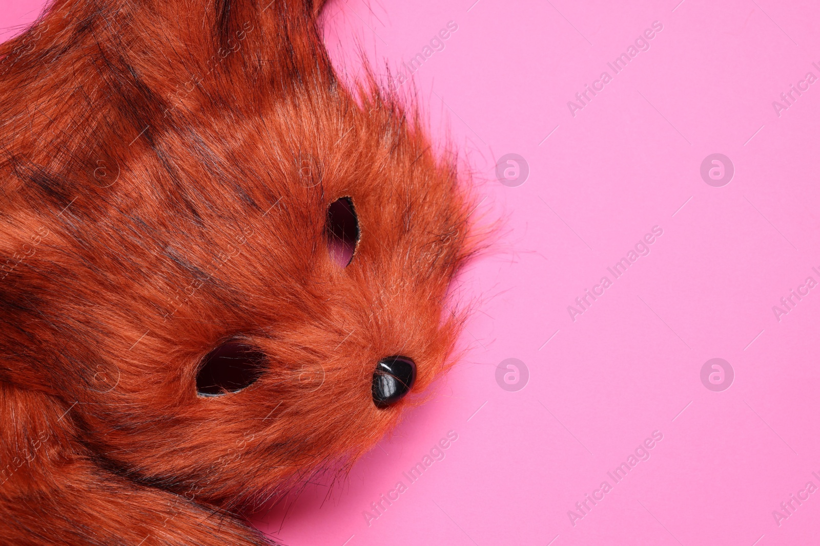 Photo of Quadrobics. Fox mask and tail on pink background, top view. Space for text