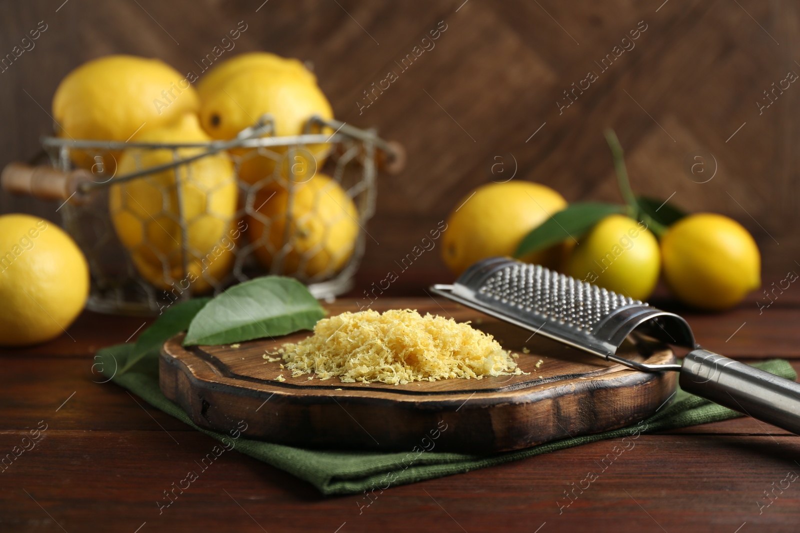 Photo of Lemon zest, grater and fresh fruits on wooden table