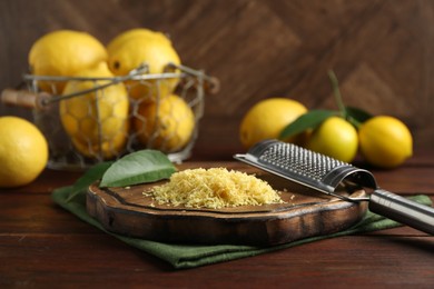 Photo of Lemon zest, grater and fresh fruits on wooden table