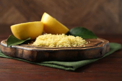 Photo of Lemon zest and fresh fruit pieces on wooden table, closeup