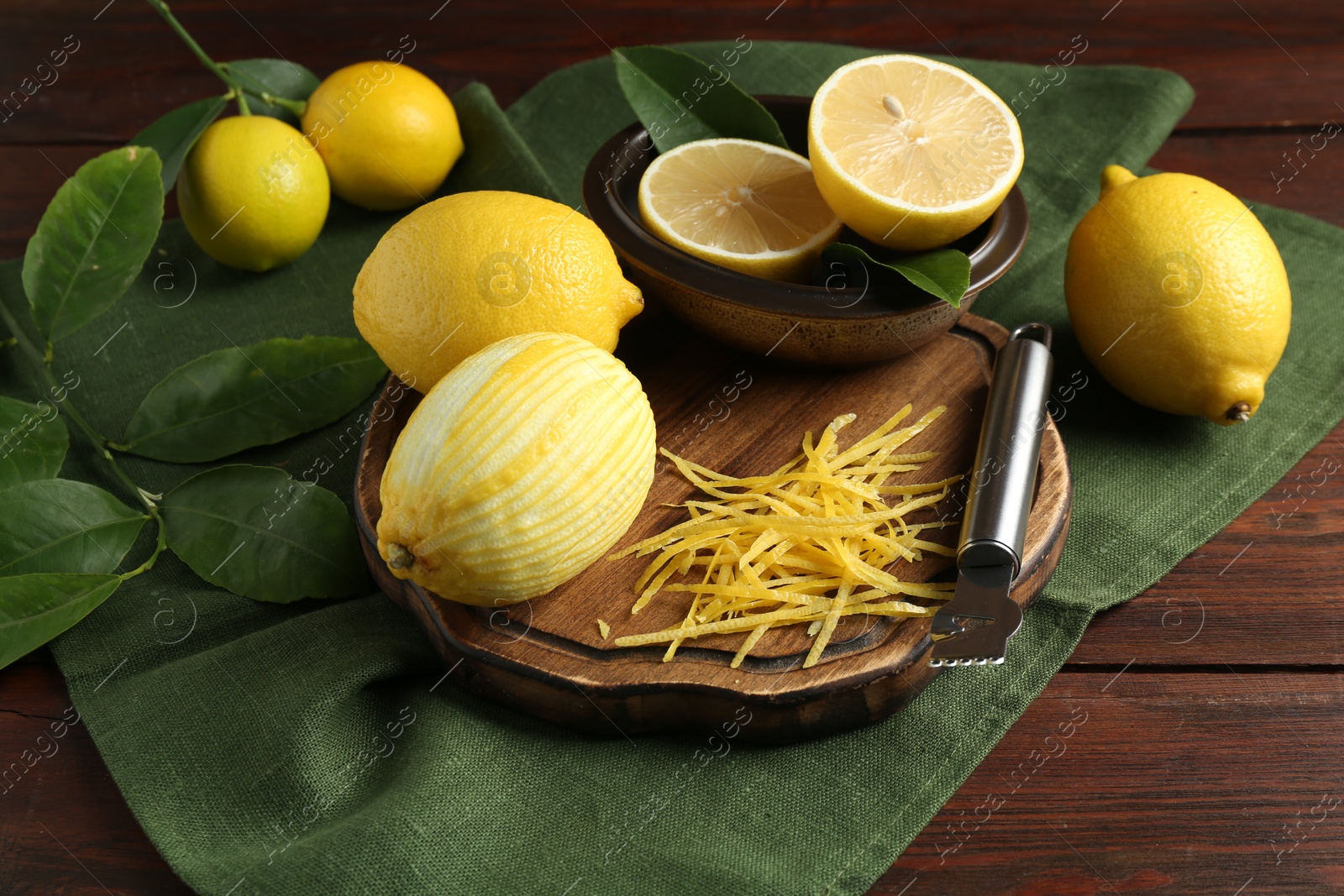 Photo of Lemon zest, zester tool and fresh fruits on wooden table