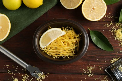 Photo of Lemon zest, tools and fresh fruits on wooden table, flat lay