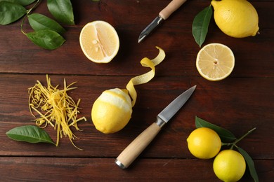 Photo of Lemon zest, knives and fresh fruits on wooden table, flat lay