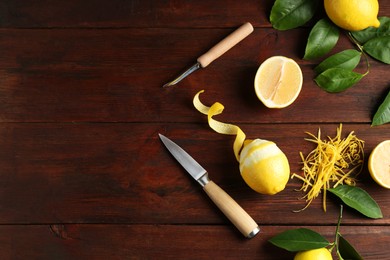 Photo of Lemon zest, knives and fresh fruits on wooden table, flat lay. Space for text