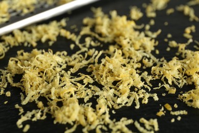 Photo of Fresh lemon zest and grater on slate board, closeup