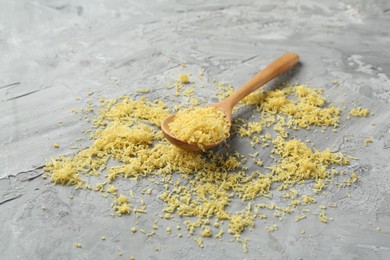 Photo of Lemon zest and spoon on grey textured table