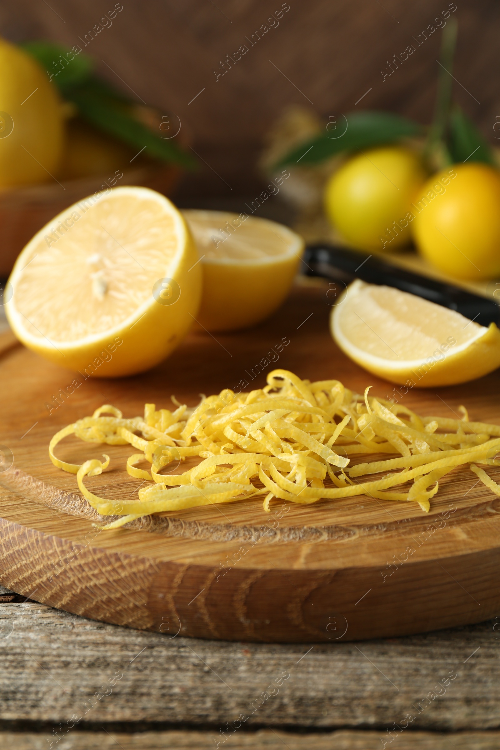 Photo of Lemon zest and fresh fruits on wooden table, closeup