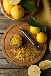 Photo of Lemon zest, zester tool and fresh fruits on wooden table, flat lay