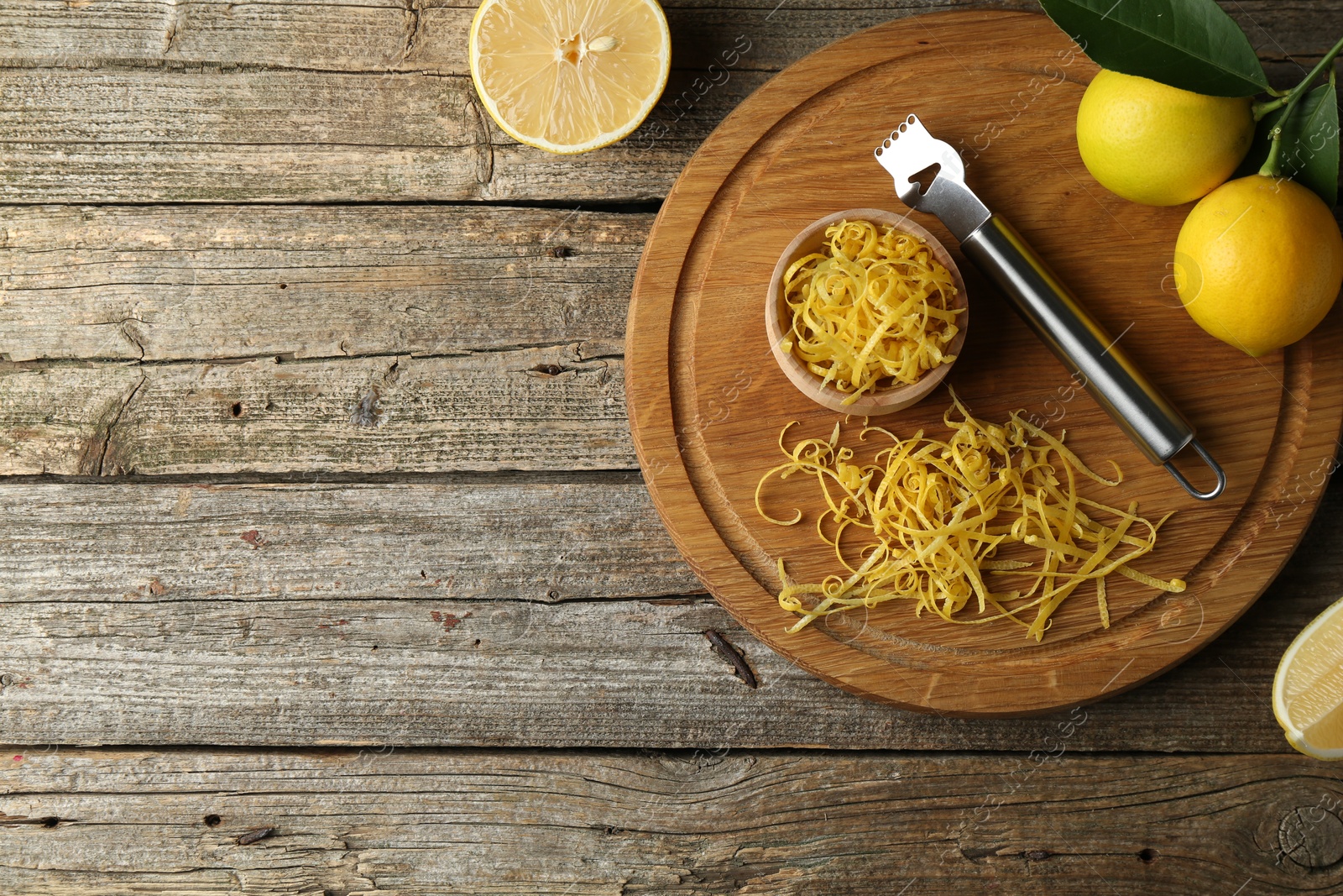 Photo of Lemon zest, zester tool and fresh fruits on wooden table, flat lay. Space for text