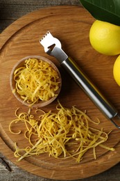 Photo of Lemon zest, zester tool and fresh fruits on wooden table, flat lay