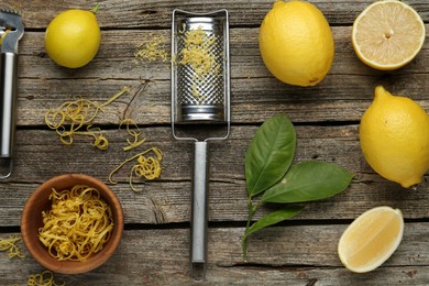 Photo of Lemon zest, tools and fresh fruits on wooden table, flat lay