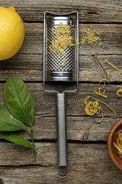 Photo of Lemon zest, grater and fresh fruit on wooden table, flat lay