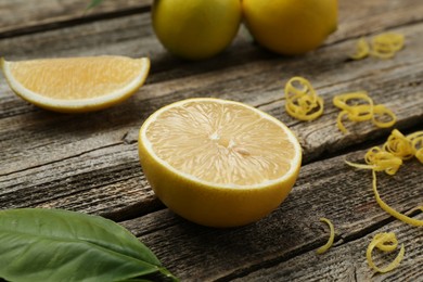 Photo of Lemon zest and pieces on wooden table, closeup