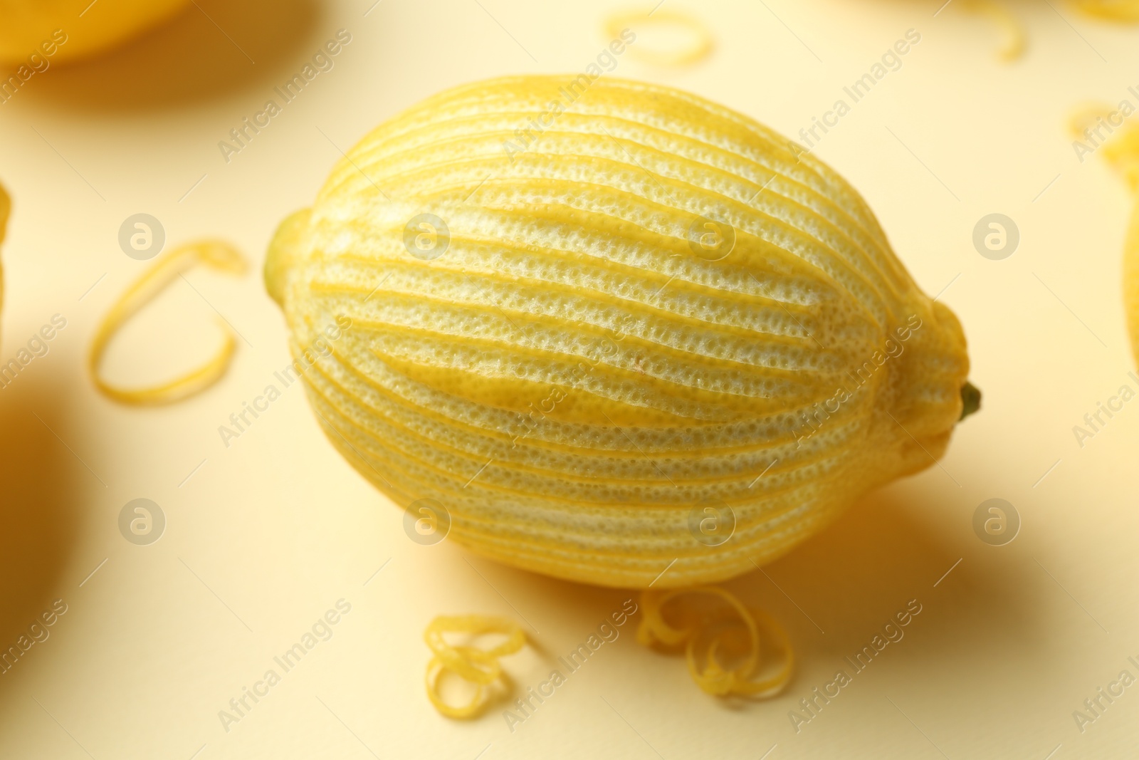 Photo of Lemon zest and fresh fruit on beige background, closeup