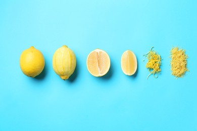 Photo of Lemon zest, whole and cut fresh fruits on light blue background, flat lay