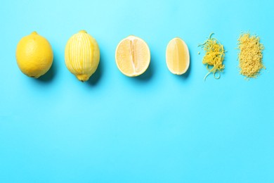 Photo of Lemon zest, whole and cut fresh fruits on light blue background, flat lay. Space for text