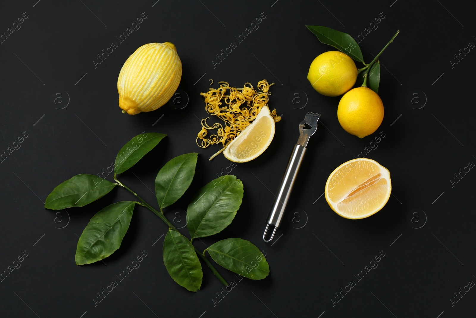 Photo of Lemon zest, zester tool, fresh fruits and leaves on black background, flat lay