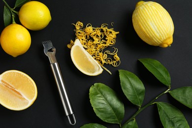 Photo of Lemon zest, zester tool, fresh fruits and leaves on black background, flat lay