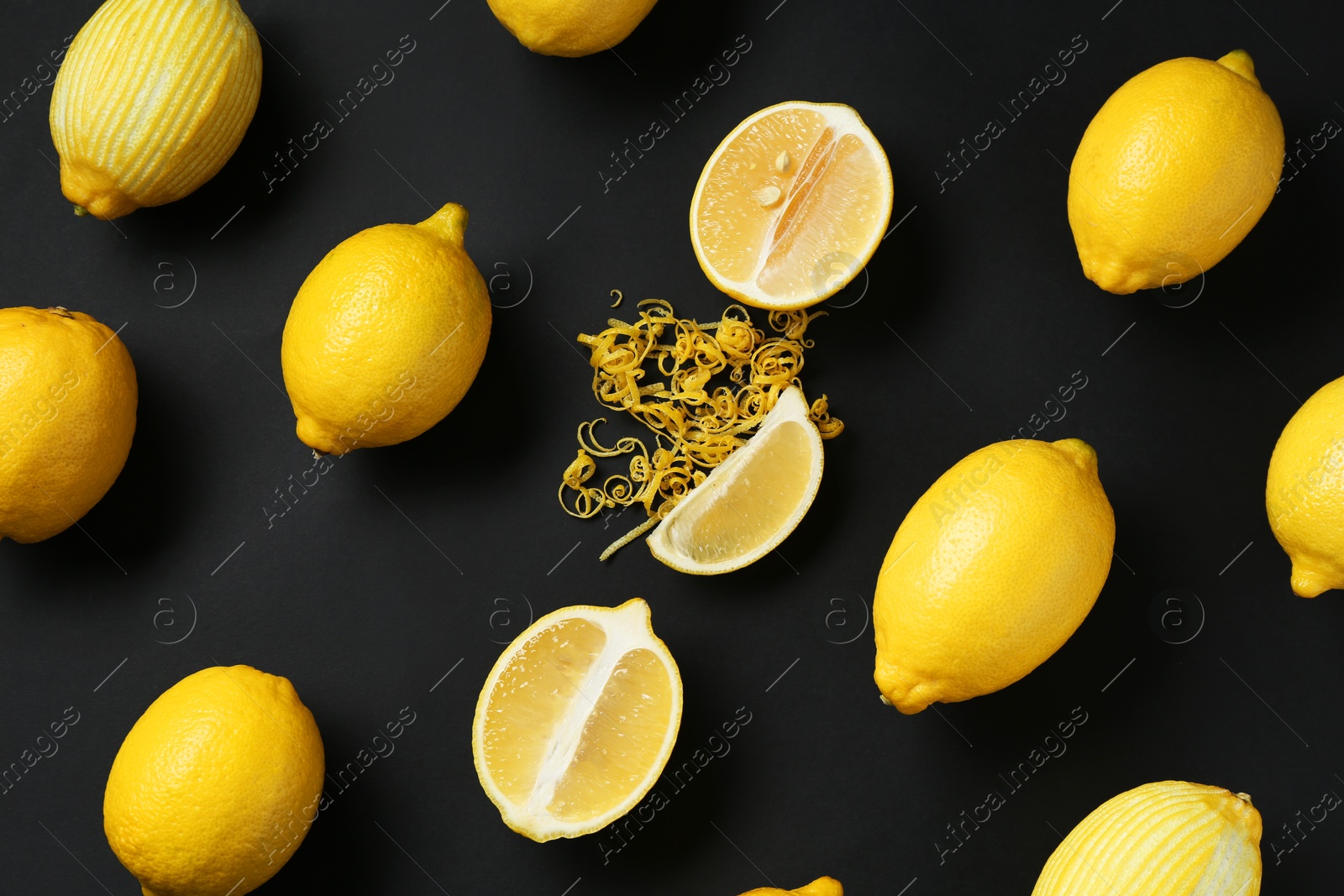 Photo of Lemon zest and fresh fruits on black background, flat lay