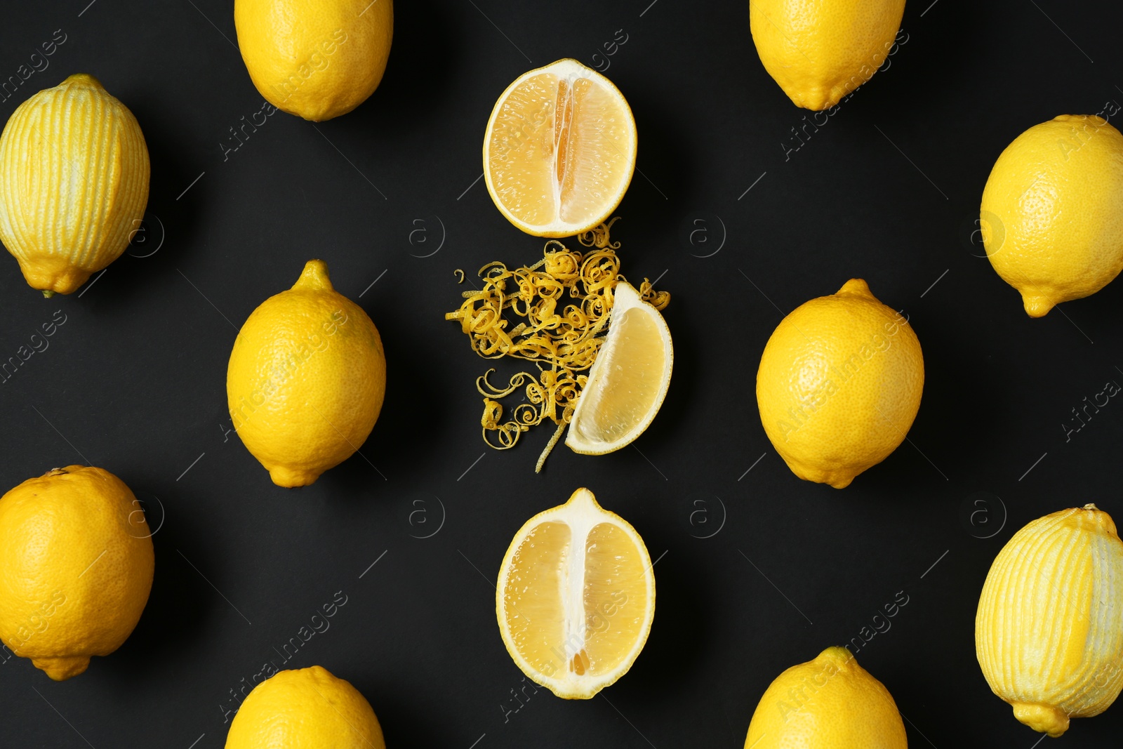 Photo of Lemon zest and fresh fruits on black background, flat lay