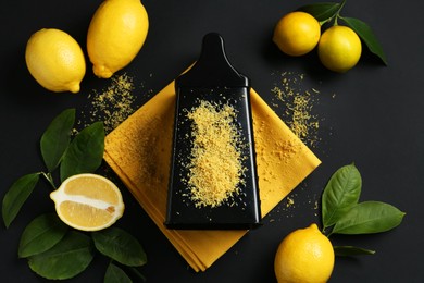 Photo of Grater with lemon zest, fresh fruits and leaves on black background, flat lay