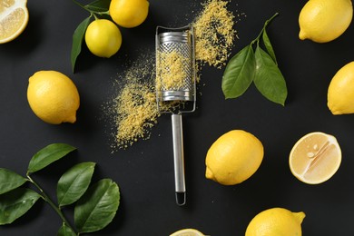 Photo of Grater with lemon zest, fresh fruits and leaves on black background, flat lay