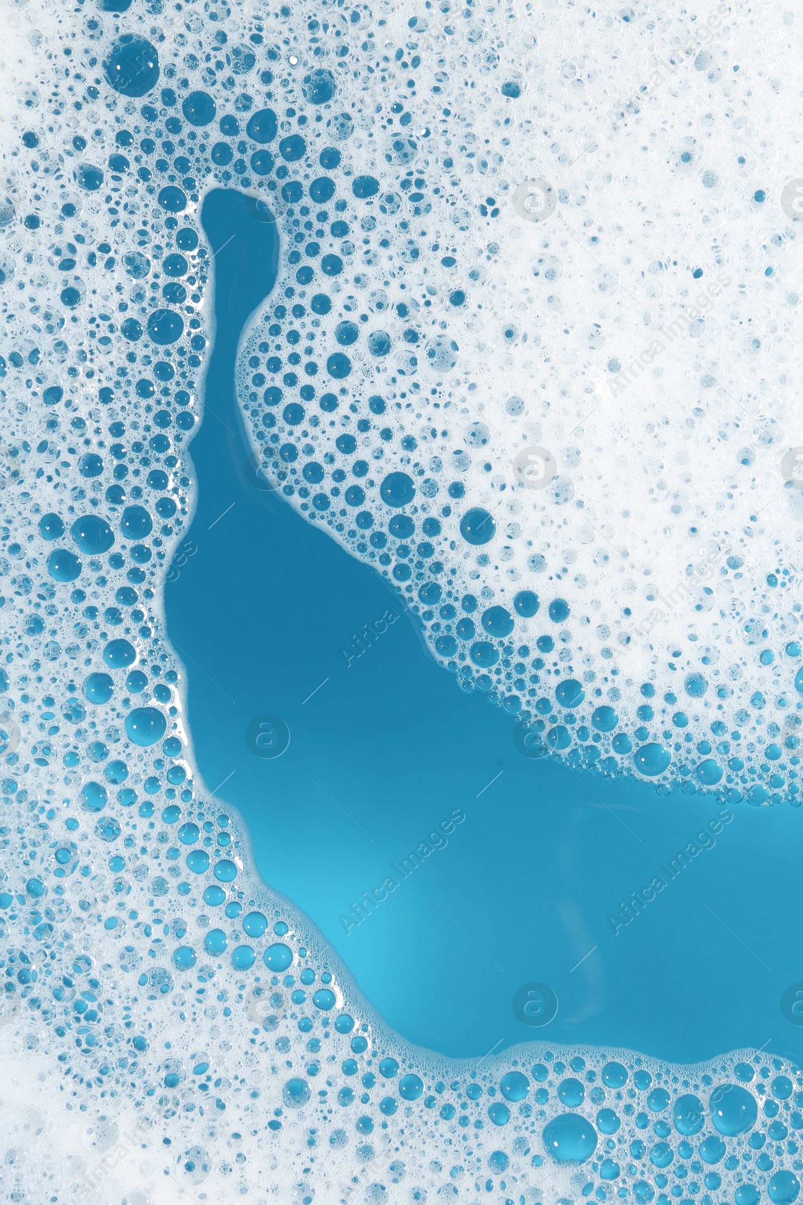 Photo of Detergent foam with bubbles on light blue background, top view