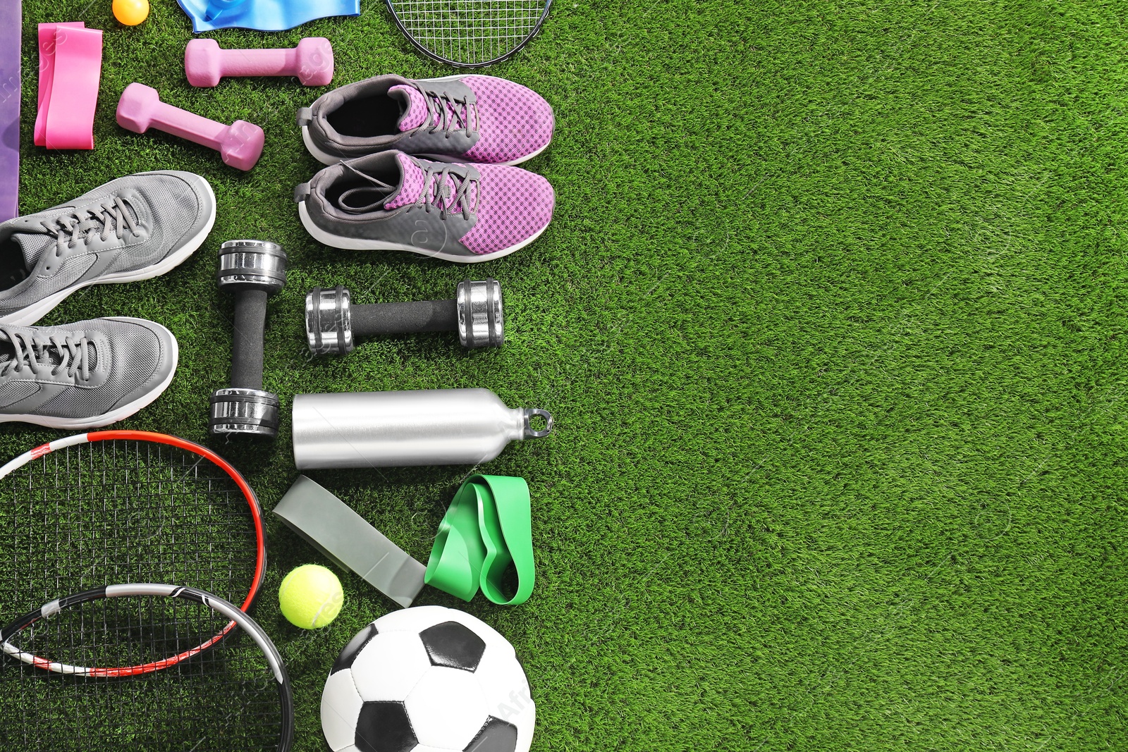 Photo of Different sport equipment on artificial grass, flat lay. Space for text