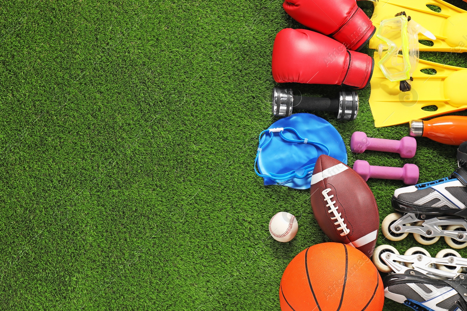 Photo of Different sport equipment on artificial grass, flat lay. Space for text