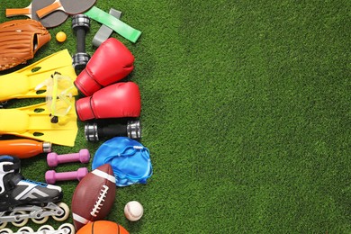 Photo of Different sport equipment on artificial grass, flat lay. Space for text