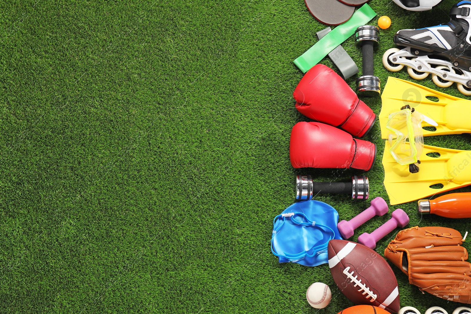 Photo of Different sport equipment on artificial grass, flat lay. Space for text