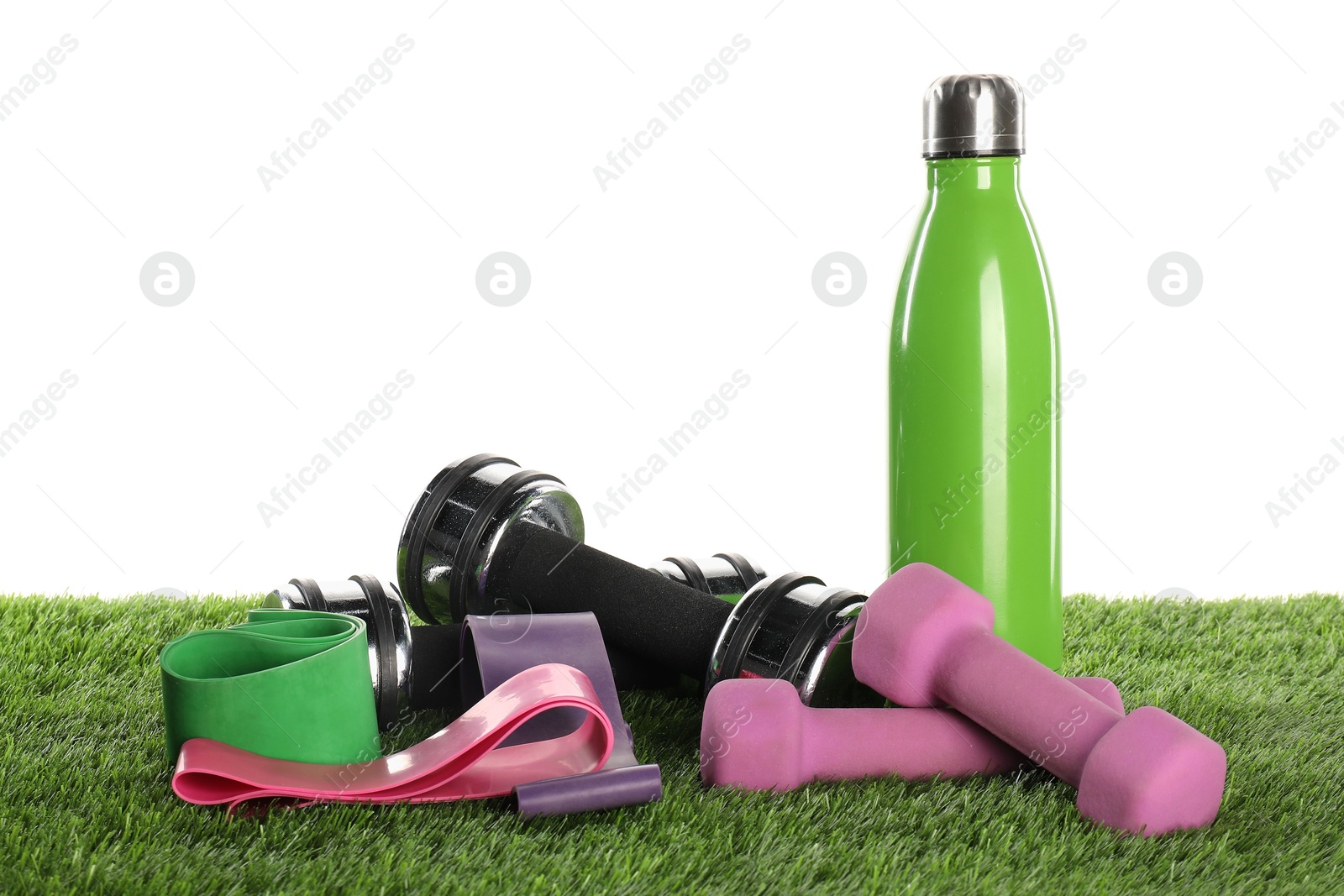 Photo of Different sport equipment on artificial grass isolated on white